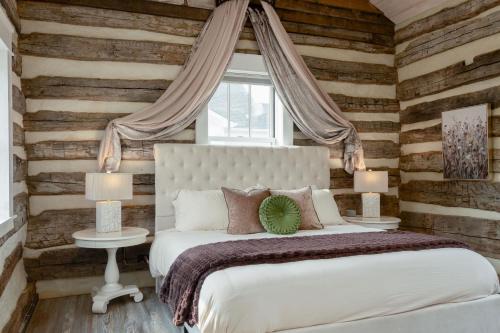 a bedroom with wooden walls and a bed and two lamps at Boutique Luxury Stay Near JMU with 2 King Suites & Fireplaces in Grottoes