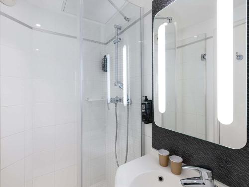 a white bathroom with a sink and a mirror at ibis Paris Gare du Nord TGV in Paris