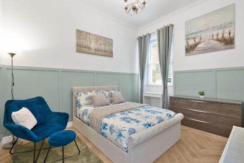 a bedroom with a bed and a blue chair at The Barony Fox in Edinburgh