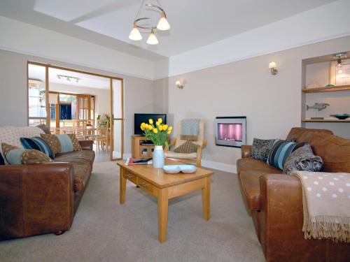 Una sala de estar con sofás y una mesa de café. en Cerniw - Cottage, en Aberaeron