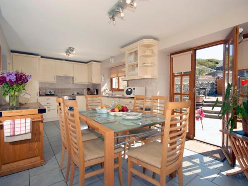 Una cocina con una mesa y sillas en una cocina. en Cerniw - Cottage, en Aberaeron