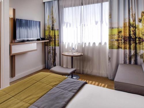 Ένα ή περισσότερα κρεβάτια σε δωμάτιο στο Hôtel Mercure Mâcon Bord de Saône