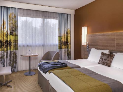 Ένα ή περισσότερα κρεβάτια σε δωμάτιο στο Hôtel Mercure Mâcon Bord de Saône
