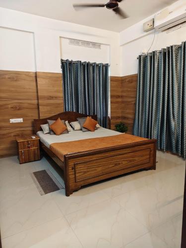 a bedroom with a large wooden bed and curtains at Harichandhanam Inn - Entire Flat, Ground Floor, 200m From East Nada Guruvayur in Guruvāyūr