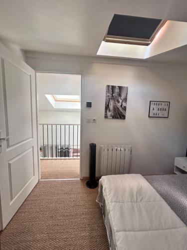 ein Schlafzimmer mit einem Bett und einem Dachfenster in der Unterkunft Duplex - T3 in Portet-sur-Garonne