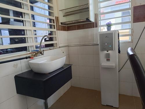 a bathroom with a white sink and a window at Ateh's Homestay KLIA in Sepang
