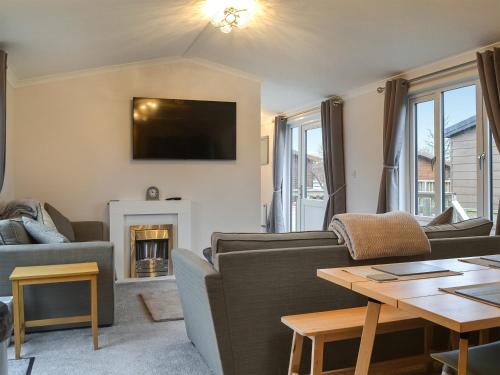 a living room with a couch and a fireplace at Harwood Lodge - Uk45602 in Wilberfoss
