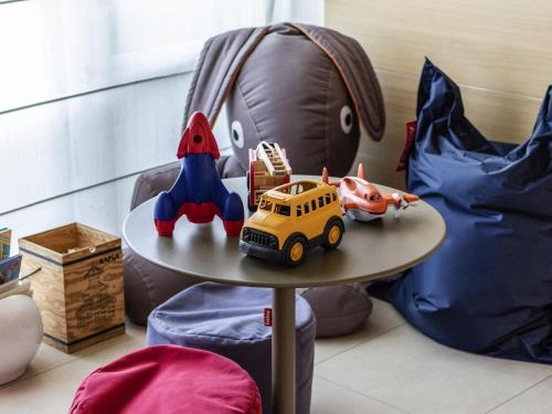 a table with a toy bus and a stuffed animal at Novotel Brussels Centre Midi in Brussels