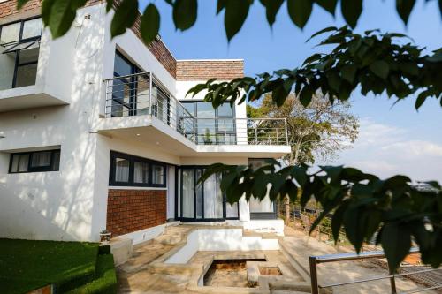 a house with a balcony on top of it at Hayhill Treetop Escape in Harare
