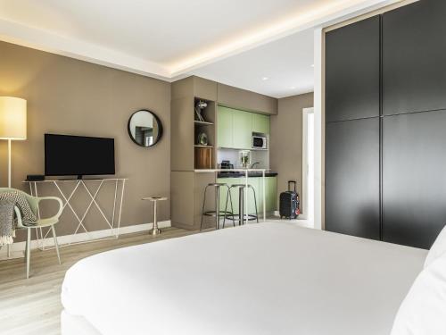 a bedroom with a large bed and a tv at Aparthotel Adagio Rome Vatican in Rome