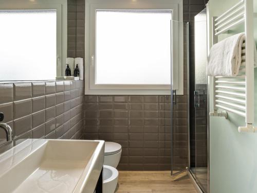 a bathroom with a tub and a toilet and a window at Aparthotel Adagio Rome Vatican in Rome