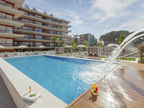 a swimming pool with a fountain in front of a building at Aparthotel Adagio Rome Vatican in Rome