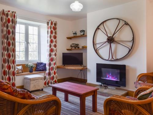 a living room with a large wheel on the wall at Pickled Onion Cottage in Taunton