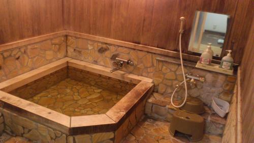 a large stone tub in a bathroom with a sink at Ryoso Kawaguchi in Miyajima