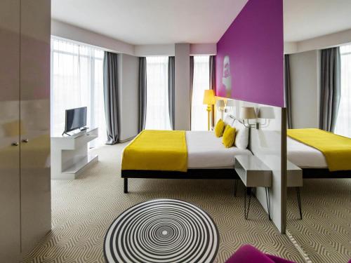 a hotel room with a bed and a tv at Ibis Styles Wroclaw Centrum in Wrocław