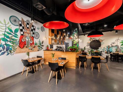 a restaurant with tables and chairs in a room at Ibis Styles Wroclaw Centrum in Wrocław