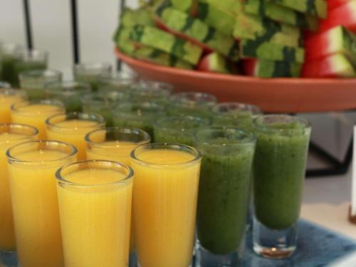 a bunch of glasses of orange and green juice at Ibis Styles Wroclaw Centrum in Wrocław