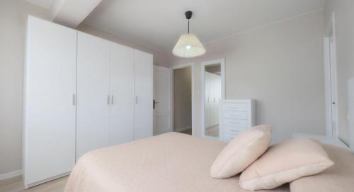 a bedroom with white walls and a bed with pillows at AMPLIO APARTAMENTO EN BURELA in Burela de Cabo