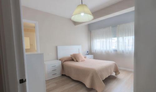 a white bedroom with a bed and a mirror at AMPLIO APARTAMENTO EN BURELA in Burela de Cabo