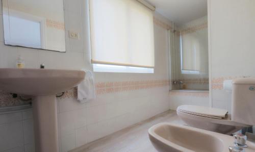 a bathroom with a sink and a toilet and a window at AMPLIO APARTAMENTO EN BURELA in Burela de Cabo