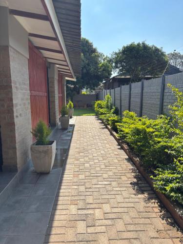 a brick walkway next to a building with potted plants at 59 van Heerden in Mokopane