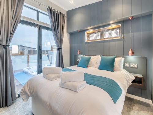 a bedroom with a large bed and a large window at Lakeside Lodge in Barholm