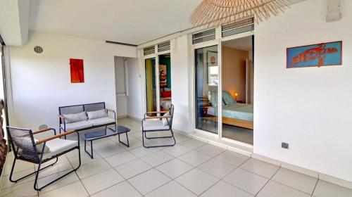 sala de estar con sillas, mesa y cama en Au Clair de Ville, en Fort-de-France
