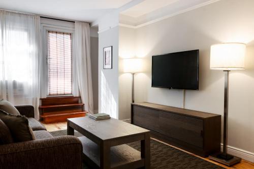 a living room with a couch and a tv at The Bayard in New York