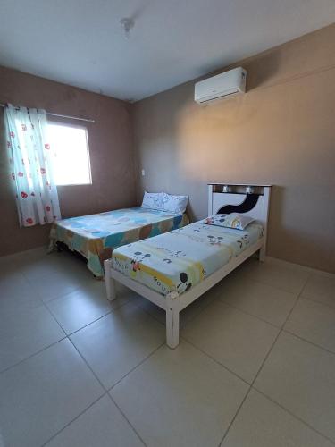 sypialnia z dwoma łóżkami i oknem w obiekcie Sonho de Verão - Casa de Praia, Pitimbu PB - 50 Metros do mar - QUASE PÉ NA AREIA w mieście Pitimbu