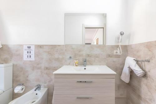 a bathroom with a sink and a toilet and a mirror at Jungle Holiday Villa in Marina dʼAvola