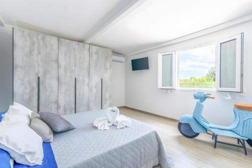 a bedroom with a bed and a blue scooter at Jungle Holiday Villa in Marina dʼAvola