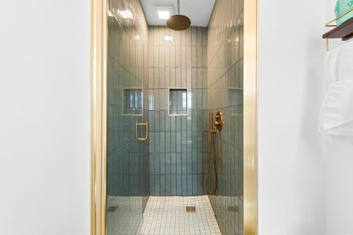 y baño con ducha de azulejos azules. en Bianco Hotel, en Miami