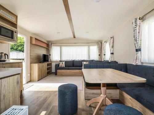 a living room with a blue couch and a table at 82 Hillside in Newquay