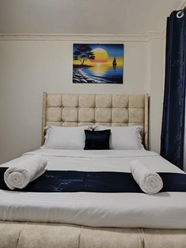 a bedroom with a large bed with a large headboard at Infinite Stays in Thika
