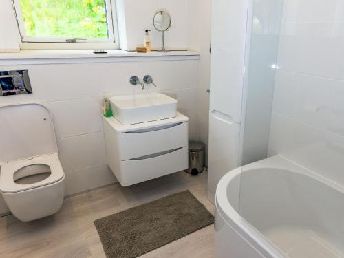 a bathroom with a sink and a toilet and a tub at Ferry House in Bonawe