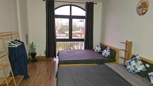 a bedroom with two beds and a large window at ADRI Hotel in Phu Quoc