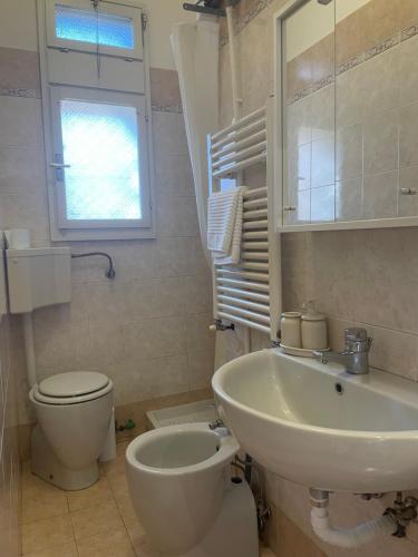 a bathroom with a sink and a toilet and a window at La Casetta in Bologna