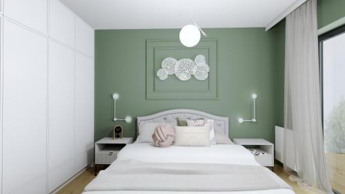 ein Schlafzimmer mit einem weißen Bett und einer grünen Wand in der Unterkunft Apartament Margaret in Oppeln
