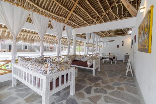 a room with two beds and a table at Leopard House in Watamu