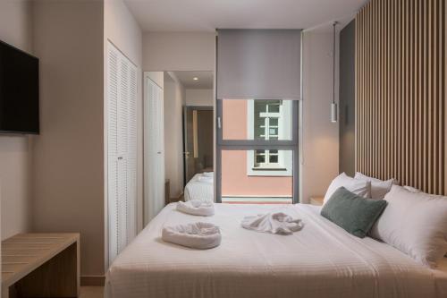a bedroom with a bed with towels on it at Trianon Luxury Apartments & Suites in Chania Town