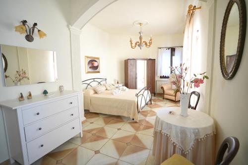 a bedroom with a bed and a table with a dresser at Rosemary Home in Barrafranca
