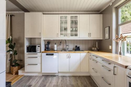 a kitchen with white cabinets and a white refrigerator at Tveitopark Apartments NO 2 in Øverland