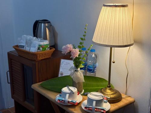 a table with a lamp and a green plate on it at Kama Siri Koh Kood in Ko Kood