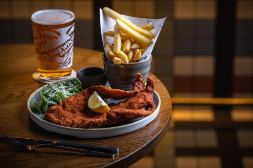 a plate of food with french fries and a drink at Royal National Hotel in London