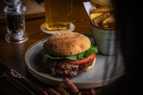 a hamburger on a plate on a table with fries at Royal National Hotel in London