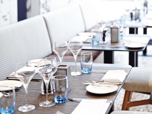 a table with wine glasses and plates on it at Novotel London Wembley in London