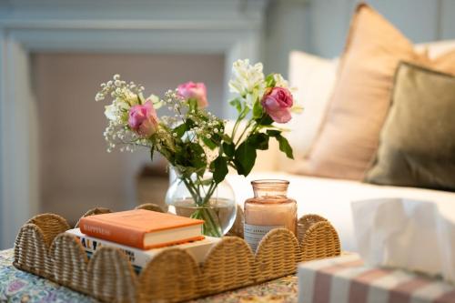 a tray with books and flowers on a table at Boutique Cottage in the Heart of Kintbury in Kintbury