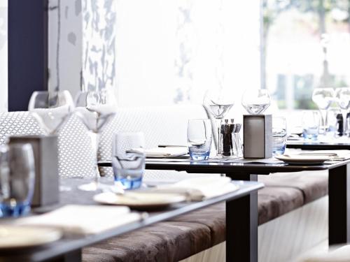 a table with glasses and plates on it at a restaurant at Novotel London Wembley in London