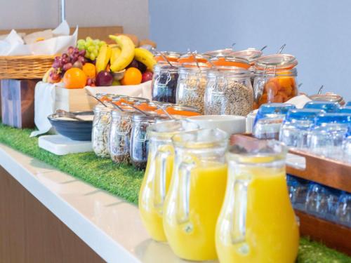 a buffet with jars of orange juice and fruit at Novotel London Wembley in London