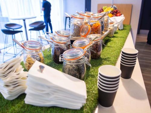 a table with jars of food on a green table cloth at Novotel London Wembley in London